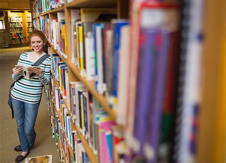 simsearch:6109-07497515,k - Cheerful student reading book leaning on shelf in library at the university Photographie de stock - Aubaine LD & Abonnement, Code: 400-07267633