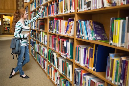 simsearch:400-07267769,k - Redhead student taking book from shelf in the library at the university Stock Photo - Budget Royalty-Free & Subscription, Code: 400-07267655