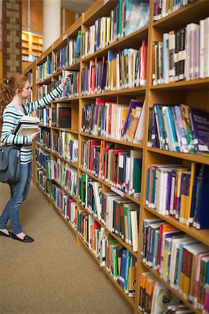 simsearch:400-07267769,k - Redhead student taking book from bookshelf in the library at the university Stock Photo - Budget Royalty-Free & Subscription, Code: 400-07267656