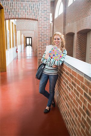 simsearch:400-07267769,k - Happy student smiling at camera in the hall holding folders at the university Stock Photo - Budget Royalty-Free & Subscription, Code: 400-07267667