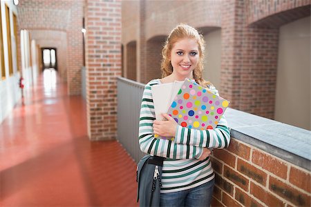 simsearch:400-07267769,k - Young student smiling at camera in the hall holding folders at the university Stock Photo - Budget Royalty-Free & Subscription, Code: 400-07267669