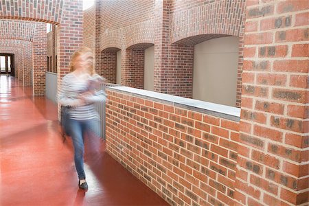 simsearch:400-07267769,k - Young student walking in the hall holding folders at the university Stock Photo - Budget Royalty-Free & Subscription, Code: 400-07267671