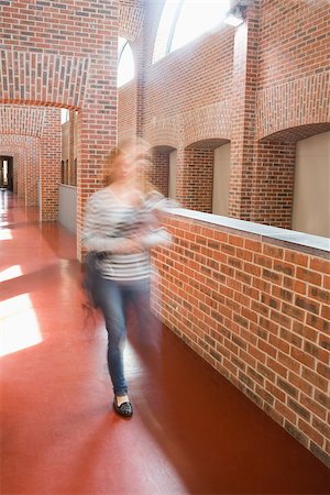 simsearch:400-07267769,k - Young student rushing in the hall holding folders at the university Stock Photo - Budget Royalty-Free & Subscription, Code: 400-07267673