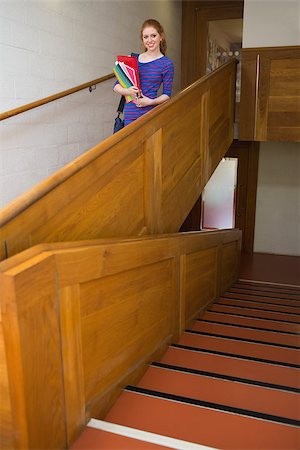 simsearch:400-07267769,k - Happy student holding folders on the stairs looking at camera at the university Stock Photo - Budget Royalty-Free & Subscription, Code: 400-07267687