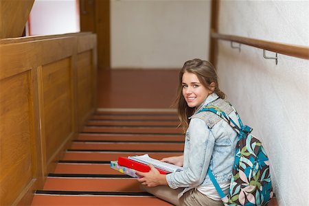 simsearch:400-07267769,k - Happy young student sitting on stairs looking up at camera in college Stock Photo - Budget Royalty-Free & Subscription, Code: 400-07267753