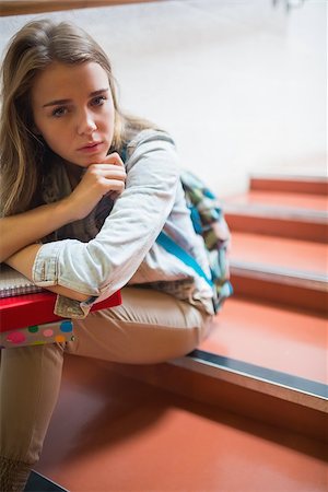 simsearch:400-07267769,k - Troubled lonely student sitting on stairs looking at camera in college Stock Photo - Budget Royalty-Free & Subscription, Code: 400-07267771