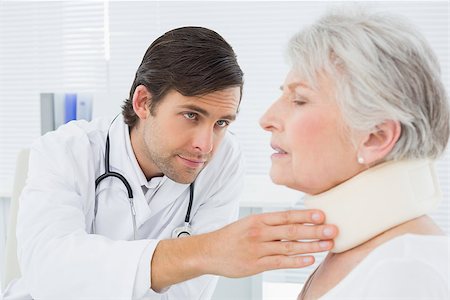 simsearch:400-07269643,k - Male doctor examining a senior patient's neck in the medical office Fotografie stock - Microstock e Abbonamento, Codice: 400-07267795