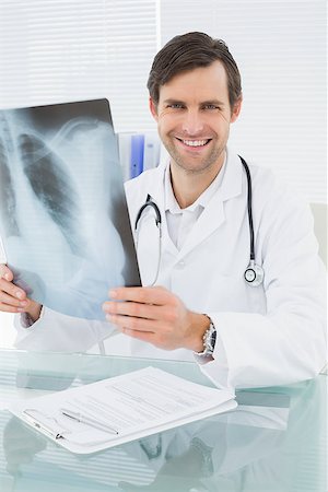 simsearch:400-07778150,k - Portrait of a smiling male doctor with lungs x-ray in the medical office Stock Photo - Budget Royalty-Free & Subscription, Code: 400-07267814