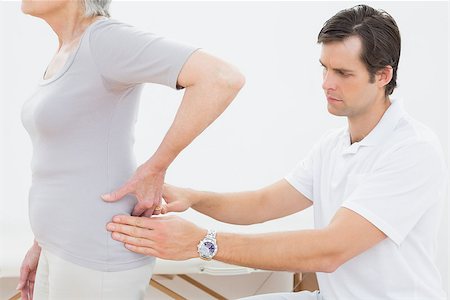 Side view of a male physiotherapist examining senior woman's back in the medical office Photographie de stock - Aubaine LD & Abonnement, Code: 400-07267875