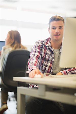 simsearch:400-07267978,k - Happy student looking at camera in the computer room in college Stock Photo - Budget Royalty-Free & Subscription, Code: 400-07267944