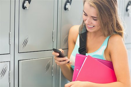 simsearch:400-04649503,k - Laughing student sending a text beside lockers in college Stock Photo - Budget Royalty-Free & Subscription, Code: 400-07268031