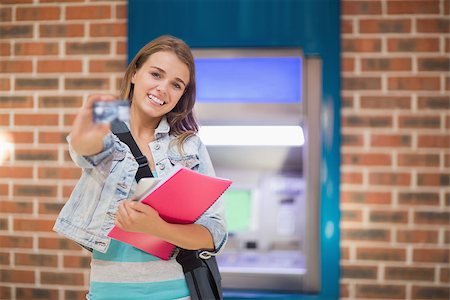 Pretty student standing showing her card to camera at the atmin college Stock Photo - Budget Royalty-Free & Subscription, Code: 400-07268054