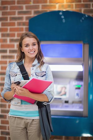 simsearch:400-07142149,k - Pretty student standing smiling at camera at the atm in college Stock Photo - Budget Royalty-Free & Subscription, Code: 400-07268053