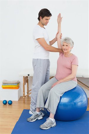Senior woman sitting on yoga ball while working with a physical therapist Stock Photo - Budget Royalty-Free & Subscription, Code: 400-07268107