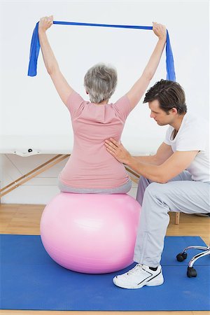 simsearch:400-07232187,k - Senior woman sitting on yoga ball while working with a physical therapist Foto de stock - Royalty-Free Super Valor e Assinatura, Número: 400-07268124