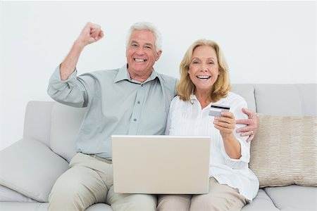 Cheerful senior couple doing online shopping through laptop and credit card on sofa in a house Stock Photo - Budget Royalty-Free & Subscription, Code: 400-07268814