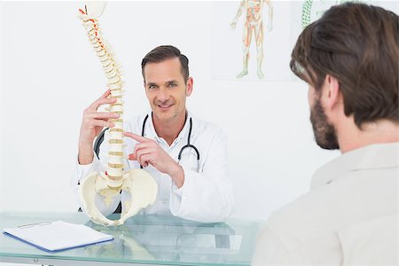 skeleton sitting down - Portrait of a male doctor explaining the spine to a patient in medical office Stock Photo - Budget Royalty-Free & Subscription, Code: 400-07269034