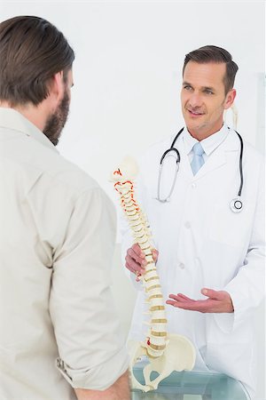 Male doctor explaining the spine to a patient in medical office Stockbilder - Microstock & Abonnement, Bildnummer: 400-07269112