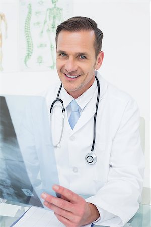 simsearch:400-07269643,k - Portrait of a smiling male doctor with x-ray picture in the medical office Fotografie stock - Microstock e Abbonamento, Codice: 400-07269244