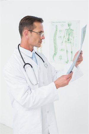 simsearch:400-07269250,k - Concentrated male doctor looking at spine x-ray in the medical office Stock Photo - Budget Royalty-Free & Subscription, Code: 400-07269266