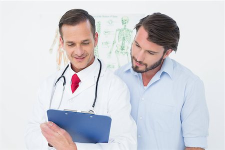 simsearch:400-07269643,k - Male doctor discussing reports with patient in the medical office Fotografie stock - Microstock e Abbonamento, Codice: 400-07269334