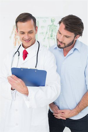 simsearch:400-07269643,k - Male doctor discussing reports with patient in the medical office Fotografie stock - Microstock e Abbonamento, Codice: 400-07269337