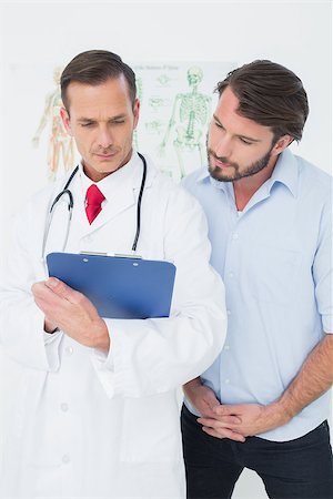 simsearch:400-07269643,k - Male doctor discussing reports with patient in the medical office Fotografie stock - Microstock e Abbonamento, Codice: 400-07269340