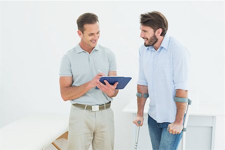 simsearch:400-07269643,k - Male therapist discussing reports with a disabled patient in the medical office Fotografie stock - Microstock e Abbonamento, Codice: 400-07269417