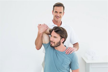 simsearch:400-04337005,k - Male physiotherapist stretching a young man's arm in the medical office Foto de stock - Super Valor sin royalties y Suscripción, Código: 400-07269504