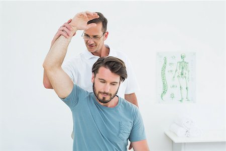 simsearch:400-04337005,k - Male physiotherapist stretching a young man's arm in the medical office Foto de stock - Super Valor sin royalties y Suscripción, Código: 400-07269509