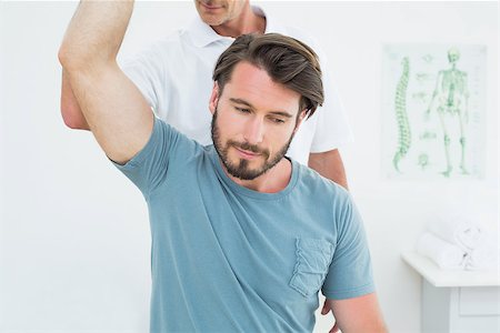 simsearch:400-04337005,k - Male physiotherapist stretching a young man's arm in the medical office Foto de stock - Super Valor sin royalties y Suscripción, Código: 400-07269512