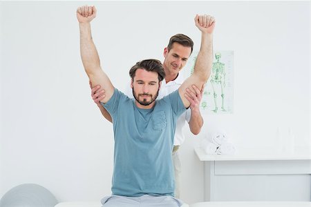 simsearch:400-04337005,k - Male physiotherapist stretching a young man's arms in the medical office Foto de stock - Super Valor sin royalties y Suscripción, Código: 400-07269557