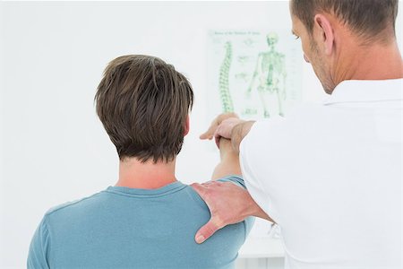 simsearch:400-04337005,k - Rear view of a male physiotherapist stretching a young man's arm in the medical office Foto de stock - Super Valor sin royalties y Suscripción, Código: 400-07269559