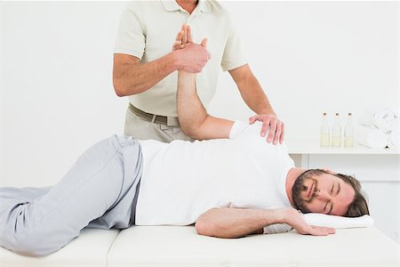 simsearch:400-04337005,k - Male physiotherapist examining a young man's hand in the medical office Foto de stock - Super Valor sin royalties y Suscripción, Código: 400-07269761