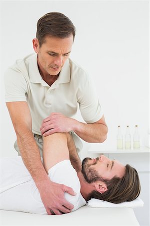 simsearch:400-04337005,k - Male physiotherapist stretching a young man's hand in the medical office Foto de stock - Super Valor sin royalties y Suscripción, Código: 400-07269778