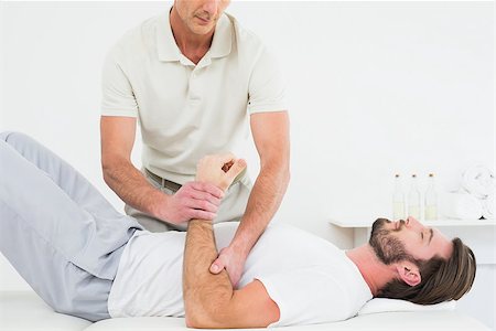 simsearch:400-04337005,k - Male physiotherapist examining a young man's hand in the medical office Foto de stock - Super Valor sin royalties y Suscripción, Código: 400-07269808