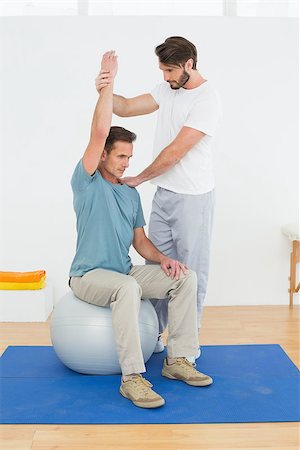 simsearch:400-07232187,k - Young man sitting on yoga ball while working with a physical therapist Foto de stock - Royalty-Free Super Valor e Assinatura, Número: 400-07269845