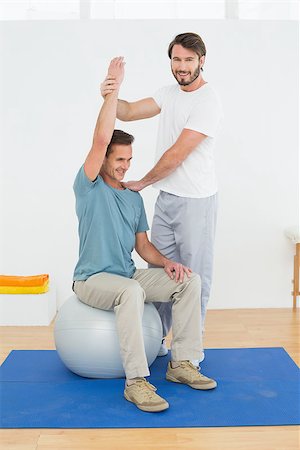 simsearch:400-07232187,k - Young man sitting on yoga ball while working with a physical therapist Foto de stock - Royalty-Free Super Valor e Assinatura, Número: 400-07269848