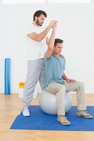 simsearch:400-07232187,k - Young man sitting on yoga ball while working with a physical therapist Foto de stock - Royalty-Free Super Valor e Assinatura, Número: 400-07269842