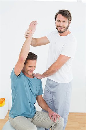 simsearch:400-07232187,k - Physical therapist assisting young man with stretching exercises in the gym hospital Foto de stock - Royalty-Free Super Valor e Assinatura, Número: 400-07269853