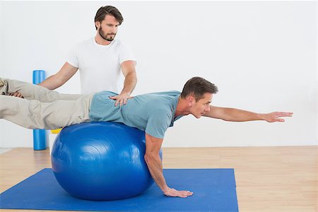 simsearch:400-07232187,k - Physical therapist assisting young man with yoga ball in the gym at hospital Foto de stock - Royalty-Free Super Valor e Assinatura, Número: 400-07269865