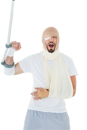 Cheerful young man with broken hand and crutch cheering over  white background Stock Photo - Budget Royalty-Free & Subscription, Code: 400-07269916