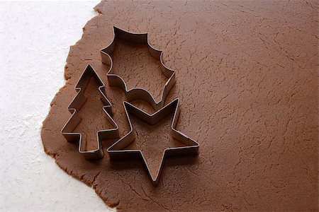 simsearch:400-07677933,k - Cutting out Christmas tree, holly leaf and star shapes from gingerbread dough Stock Photo - Budget Royalty-Free & Subscription, Code: 400-07260460