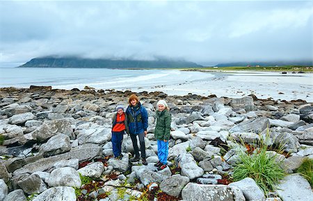 ramberg - View of the beach in Ramberg (Lofoten, Norway) and family on stones. Summer cloudy cold day. Fotografie stock - Microstock e Abbonamento, Codice: 400-07262514