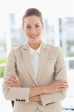 simsearch:400-07275828,k - Portrait of a young businesswoman with arms crossed smiling  in a bright office Photographie de stock - Aubaine LD & Abonnement, Code: 400-07274426