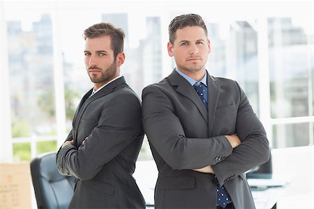 simsearch:400-07274414,k - Portrait of two young businessmen standing with arms crossed in a bright office Photographie de stock - Aubaine LD & Abonnement, Code: 400-07274444
