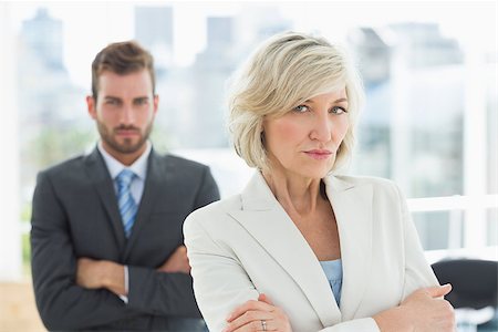 simsearch:400-07274414,k - Portrait of a mature businesswoman and young businessman standing with arms crossed in a bright office Photographie de stock - Aubaine LD & Abonnement, Code: 400-07274450