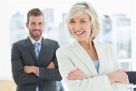 simsearch:400-07274414,k - Portrait of a mature businesswoman and young businessman standing with arms crossed in a bright office Photographie de stock - Aubaine LD & Abonnement, Code: 400-07274451