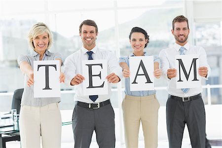 simsearch:400-07274497,k - Portrait of a smiling business team holding papers indicating team at a bright office Stock Photo - Budget Royalty-Free & Subscription, Code: 400-07274513