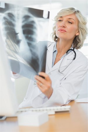 simsearch:400-07275966,k - Serious female doctor examining xray in the medical office Foto de stock - Super Valor sin royalties y Suscripción, Código: 400-07274752